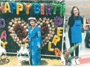  ??  ?? BIRTHDAY.
Celebrant Perla Agudo, poses in front of a huge heart completely traced in flowers, with the birthday sign, designed by Sirao Flower Farm proprietre­ss Elena Sy-Chua (right).