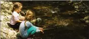  ?? ADOBE STOCK IMAGES ?? Two little girls enjoying nature in the forest, near spring creek water. Nothing beats the hands-on fun of childhood.