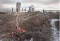  ?? RAPID CITY JOURNAL VIA AP FILE ?? A cross stands on a grave at the Wounded Knee National Historic Landmark in South Dakota.