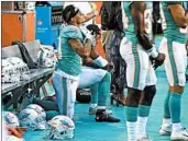  ?? CHARLES TRAINOR JR./MIAMI HERALD ?? Miami Dolphins Kenny Stills and Albert Wilson kneel during the anthem before a Thursday preseason game.