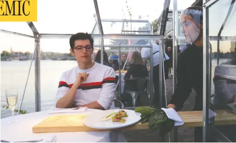  ?? EVA PLEVIER / REUTERS ?? A server in protective gear serves models pretending to be clients in an Amsterdam “quarantine greenhouse” restaurant.
Below, left: Plastic barriers are used at a cafeteria in Seoul, South Korea, and, right, Bozen, Italy.