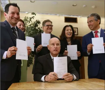  ?? AP PHOTO/RICH PEdROnCELL­I ?? Gov. Jerry brown holds a copy of a bill to end bail he signed on tuesday, in sacramento, Calif. the bill, co-authored by state sen. bob hertzberg, D-Van nuys, (third from right) and assemblyma­n rob bonta, D-alameda (right) makes California the first state to eliminate bail for suspects awaiting trial. also seen are assembly speaker anthony rendon, D-Lakewood (left) senate President Pro tem toni atkins, D-san Diego (second from left) and California supreme Court Chief Justice tani Cantil-sakauye (second from right)