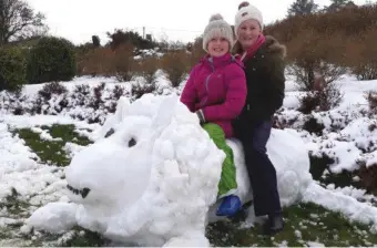  ?? Ellie Lyons from Ballyduff with her cousin Caoímhe Lyons on their snow lion in Lyreacromp­ane. ??