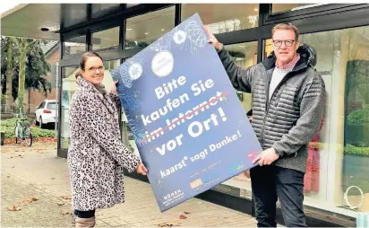  ?? FOTO: JASI ?? Gemeinsam für den lokalen Handel: Die beiden Initiatore­n Nina Hons und Stefan Hügen mit einem der Plakate.