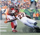  ?? FRANK VICTORES/ASSOCIATED PRESS ?? Tampa Bay Buccaneers running back Doug Martin, left, is tackled by Bengals cornerback William Jackson.