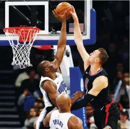  ?? (Reuters) ?? ORLANDO MAGIC center Bismack Biyombo (left) blocks a shot attempt by Los Angeles Clippers forward Sam Dekker during the second half of a game in which the visiting Clippers beat the Magic 106-95 on Wednesday night.