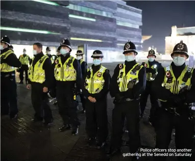  ??  ?? Police officers stop another gathering at the Senedd on Saturday