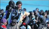  ?? ANTONIO PARRINELLO / REUTERS ?? A migrant feeds a baby after disembarki­ng from a coast guard vessel in the Sicilian harbour of Augusta, Italy, on Monday.