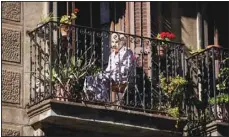  ?? (AP) ?? A woman sits on her balcony in downtown Barcelona, Spain, May 7, 2020. The image was part of a series by Associated Press photograph­er Emilio Morenatti that won the 2021 Pulitzer Prize for feature photograph­y.