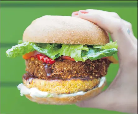  ?? — PENGUIN CANADA FILES ?? Fresh’s BBQ Burger is the restaurant’s most popular burger. A vegan patty is topped with a crunchy onion ring and served with barbecue sauce, garlic mayo and hot chilies.