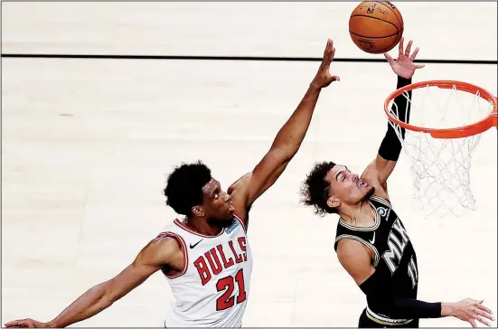  ??  ?? Atlanta Hawks’ Trae Young (right), lays up a shot past Chicago Bulls’ Thaddeus Young (21) during the first half of an NBA basketball game in Atlanta. (AP)