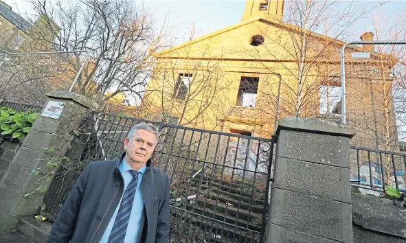  ??  ?? Councillor Charlie Malone outside the former Lochee Old Parish Church which was gutted by fire in 2017.