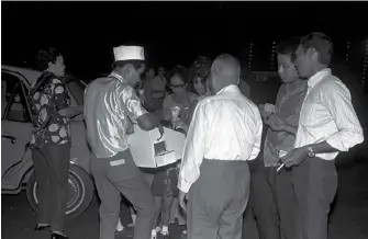  ?? ?? (Above) Guests and patrons buying ice-cream from a vendor at the Jurong Drive-in Cinema on opening night, 14 July 1971. Ministry of Informatio­n and the Arts Collection, courtesy of National Archives of Singapore