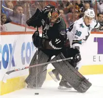  ?? CHRIS CARLSON/ASSOCIATED PRESS ?? Arizona goalie Mike Smith vies for the puck with the Sharks’ Micheal Haley.