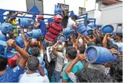  ?? (AFP) ?? Enraged crowd loot a truck transporti­ng cooking gas cylinders in Colombo on Sunday