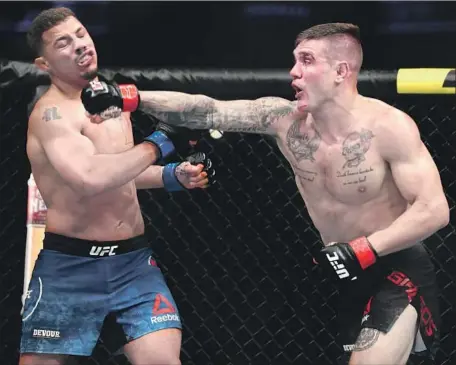  ?? Joe Scarnici Getty Images ?? CHRISTOS GIAGOS connects with a punch against Drakkar Klose in their lightweigh­t fight at UFC 241 at Honda Center in Anaheim.