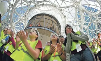  ?? TED S. WARREN, AP ?? Students from the Environmen­tal and Adventure School in Kirkland, Wash., applaud during a ceremony for the planting of an Australian Tree Fern inside the Amazon Spheres on May 4.