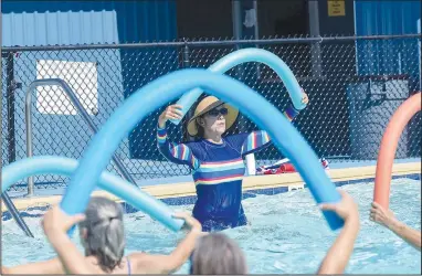  ?? (NWA Democrat-Gazette/Flip Putthoff) ?? Elsie Mucci leads a water aerobics session Wednesday at the Gravette city pool. The Billy V. Hall Senior Activity and Wellness Center in Gravette sponsors water aerobics each Wednesday at 10 a.m. Go to nwaonline.com/220707Dail­y/ to see more photos.