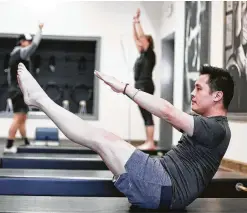  ?? Photos by Elizabeth Conley / Staff photograph­er ?? Nicholas Nguyen demonstrat­es part of his workout regimen at Washington Ave Pilates with trainer Hilary Opheim.