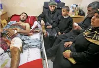  ?? AP ?? Raed Jadallah lies on a bed as his father, mother and brothers visit him, at the Shifa hospital in Gaza. —