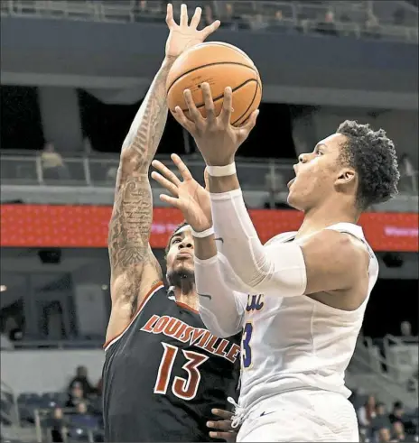  ?? Matt Freed/Post-Gazette ?? Pitt’s Shamiel Stevenson, right, scored 15 points on 5-of-8 shooting from the field, but it wasn’t enough to help the Panthers avoid a crushing 94-60 defeat against Louisville on Sunday at Petersen Events Center.