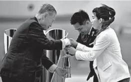  ?? PHILIP FONG/GETTY-AFP ?? Tokyo 2020 president Yoshiro Mori, left, receives the Olympic flame from Japanese three-time Olympic gold medallists Saori Yoshida, right, and Tadahiro Nomura.