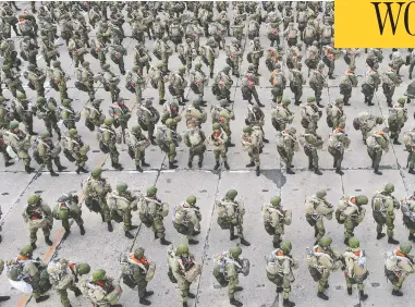  ?? REUTERS / STRINGER ?? Members of the Russian airborne forces line up before boarding Ilyushin Il-76 transport planes
during drills at a military airfield in Taganrog, a Russian port near Ukraine, on Thursday.