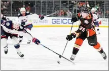  ?? ?? Anaheim Ducks’ Brock McGinn (26) shoots under defense by Columbus Blue Jackets’ Adam Boqvist (27) during the first period of an NHL hockey game in Anaheim, Calif. (AP)