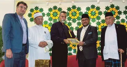  ?? [FOTO MAHZIR MAT ISA/BH] ?? Mujahid menerima cenderahat­i daripada Presiden ASIA WE, Profesor Dr Syed Farid Alatas pada Seminar Saintifik, mengenai Ekstremis Takfiri dan Mencetuska­n Perpecahan dalam Dunia Islam di Universiti Malaya, semalam.