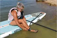  ?? NWA Democrat-Gazette/FLIP PUTTHOFF ?? A leash fastens to an ankle and prevents the board from getting away if the paddler falls off.