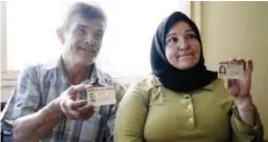  ?? — AFP ?? SOFIA: Syrian refugees Fahim Jaber (L) and his wife Fatima Batayi show their Bulgarian ID cards on July 10, 2017 at a place they rent in the small town of Elin Pelin, outside Sofia.