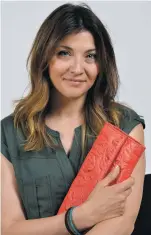  ?? CLYDE MUELLER/THE NEW MEXICAN ?? Vera Tucci, founder and designer of Italisan, holds the company’s first offering, the Lucia Clutch. Italisan is offering just 42 of the Lucia Clutch bags at $500 before June 29 and $600 thereafter.
