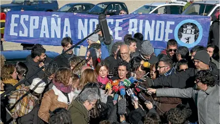  ?? PHOTO: GETTY IMAGES ?? Marta Rovira of the Republican Left of Catalonia, centre, speaks to the news media while Spain pro-unity supporters hold a banner reading ‘Spain does not give up’ ahead of parliament­ary elections.