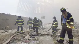  ?? AP ?? File photo shows firefighte­rs working beneath the destroyed mullions, the vertical struts which once faced the outer walls of the World Trade Center towers, after a terrorist attack on the twin towers in New York on Sept. 11, 2001.