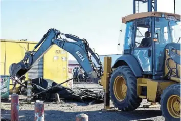  ?? Picture: ANDISA BONANI ?? DEMOLITION­S: A municipal TLB truck was seen demolishin­g temporary shelters on the corner of Victoria Road and Komani Street near Nonesi Mall on Wednesday, while the owners looked on in disbelief