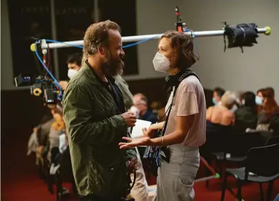  ?? Yannis Drakoulidi­s / Netflix ?? Maggie Gyllenhaal talks with her husband, actor Peter Sarsgaard, on the set of her directoria­l debut, “The Lost Daughter.” Gyllenhaal based the screenplay on the novel of the same name by Italian author Elena Ferrante.