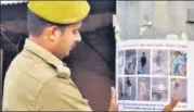  ?? ANIL KUMAR MAURYA/HT ?? A policeman pastes a poster of alleged accused in Prayagraj violence, on Wednesday.