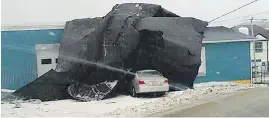  ??  ?? Gusts up to 120 kilometres an hour blew part of the roof off a nearby Home Hardware store onto this building in Channel-Port aux Basques, N.L.