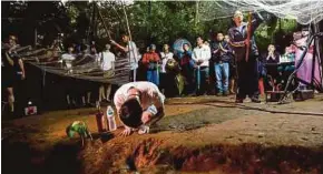  ?? AFP PIC ?? Family members and relatives praying at the entrance of Tham Luang cave in Chiang Rai province yesterday.