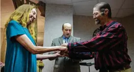  ?? Godofredo A. Vasquez / Houston Chronicle ?? Amy Graham and James Spicer hold hands as chaplain Spencer Littlejohn officiates at their wedding at Champion Forest Baptist Church Wednesday.