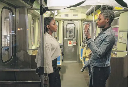  ?? UNIVERSAL PICTURES ?? “Candyman” director Nia DaCosta (right) discusses a scene on a CTA train with star Teyonah Parris.