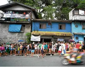  ??  ?? HOT ITEM Residents queue for NFA rice in Quezon City.