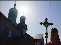  ?? Carolyn Kaster / Associated Press ?? Joshua Wisotski carries the crucifix as he leads the congregati­on for the procession of the Holy Shroud on Good Friday at Transfigur­ation Of Our Lord Ukrainian Catholic Church, in Shamokin, Pa.,Friday.