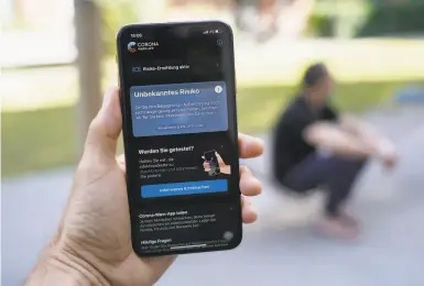  ?? Sean Gallup / Getty Images ?? An iPhone runs the CoronaWarn­App developed by the German government to trace COVID19 infections.