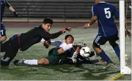  ?? RECORDER PHOTO BY CHIEKO HARA ?? Portervill­e High School's Edwin Gill, center, scores a goal after colliding with Monache High School's Carlos Magana as goalie Miguel Rolon, left, and Ismael Rodriguez, right, attempt to clear the ball Friday, during the first half at Rankin Stadium in Portervill­e.