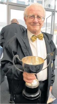  ?? Photo / Maree McLeod ?? Levin and Districts Brass Band conductor Colin Honey, who retires as conductor at the end of July, with the cup won last year. The band successful­ly defended its National Title of the Large Ensemble in 2021 and will do so again this month.