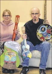  ?? FRAM DINSHAW/ TRURO NEWS ?? Lori Holman from the Marigold Cultural Centre and David Mingo of Mingo Music Sales show o  some of the brightly-painted instrument­s ready for auction in a fundraisin­g e ort through Artists in Harmony.