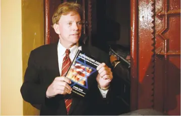  ?? (Reuters) ?? DAVID DUKE, a former Republican member of the Louisiana House of Representa­tives shows off his book. The author says the presence of men like him in politics shows how America has changed.