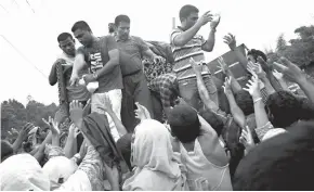  ?? Associated Press ?? n Refugees who are members of Myanmar’s Rohingya ethnic minority reach for food distribute­d by Bangladesh­i volunteers Sunday near Cox’s Bazar’s Gundum area, Bangladesh. About 73,000 people have crossed the border since violence erupted Aug. 25 in...