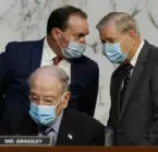  ?? Associated Press ?? Senate Judiciary Committee Chairman Sen. Lindsey Graham, standing right, talks to Sen. Mike Lee, R-Utah., as Sen. Charles Grassley, R-Iowa, sits below, before a confirmati­on hearing for Supreme Court nominee Amy Coney Barrett before the Senate Judiciary Committee Monday on Capitol Hill in Washington.